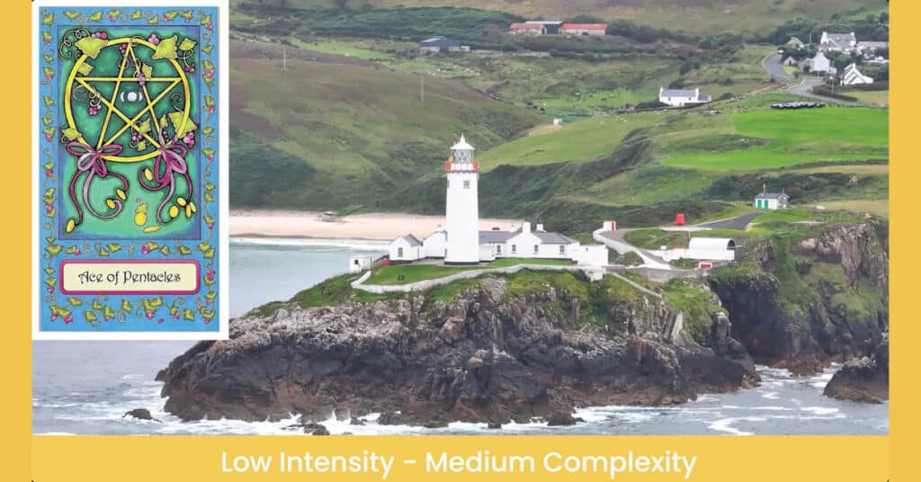Aerial view of a local lighthouse and buildings high on a rocky cliff, next to a beach, with farmland and homes behind it.